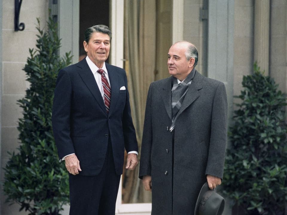Links steht der US-Präsident Ronald Reagan und rechts steht der sowjetische Präsident  Michail Gorbatschow.