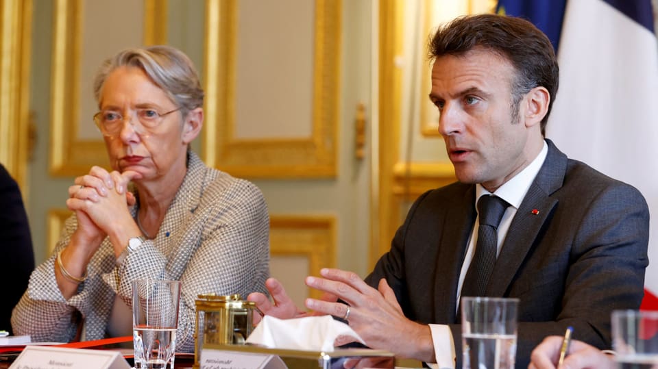 Élisabeth Borne und Emmanuel Macron mit sehr ernsten Minen am Tisch.