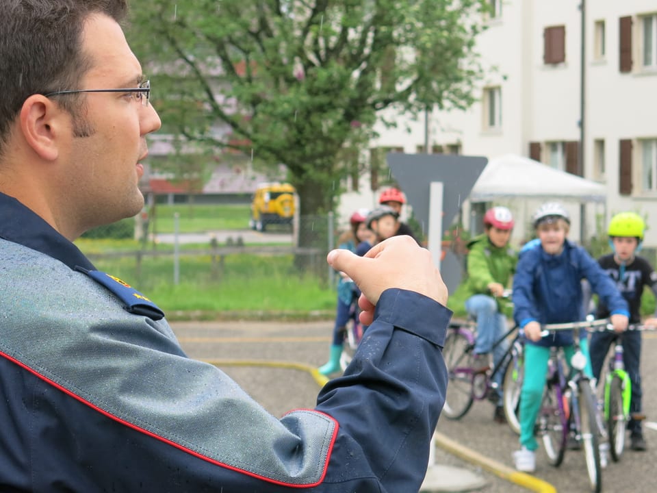 Ein Polizist in Uniform und Kinder auf Fahrrädern.