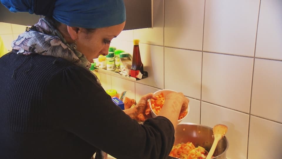 Eine Frau mit Kopftuch kocht ein muslimisches Feiertagsgericht.