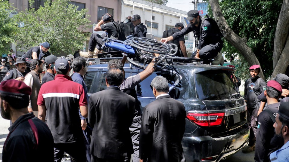 Pakistanische Sicherheitskräfte bewachen ein Fahrzeug mit Imran Khan nach seiner Verhaftung.