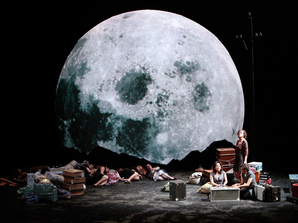 Hinter der Bühne ist ein riesengrosser Mond zu erkennen.