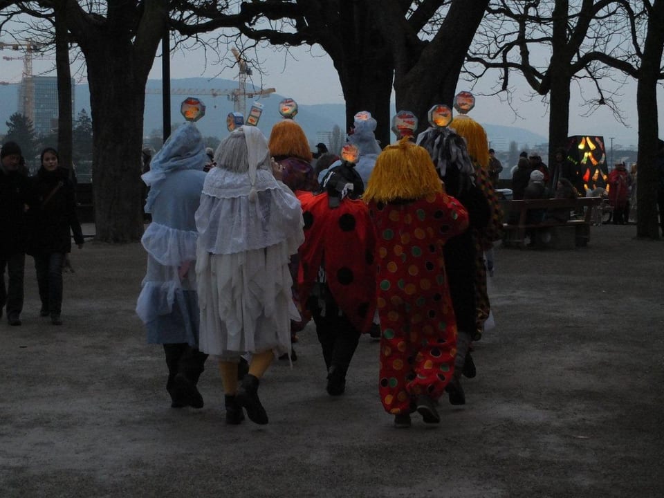 Gruppe mit Pfeifern marschieren in der Dämmerung