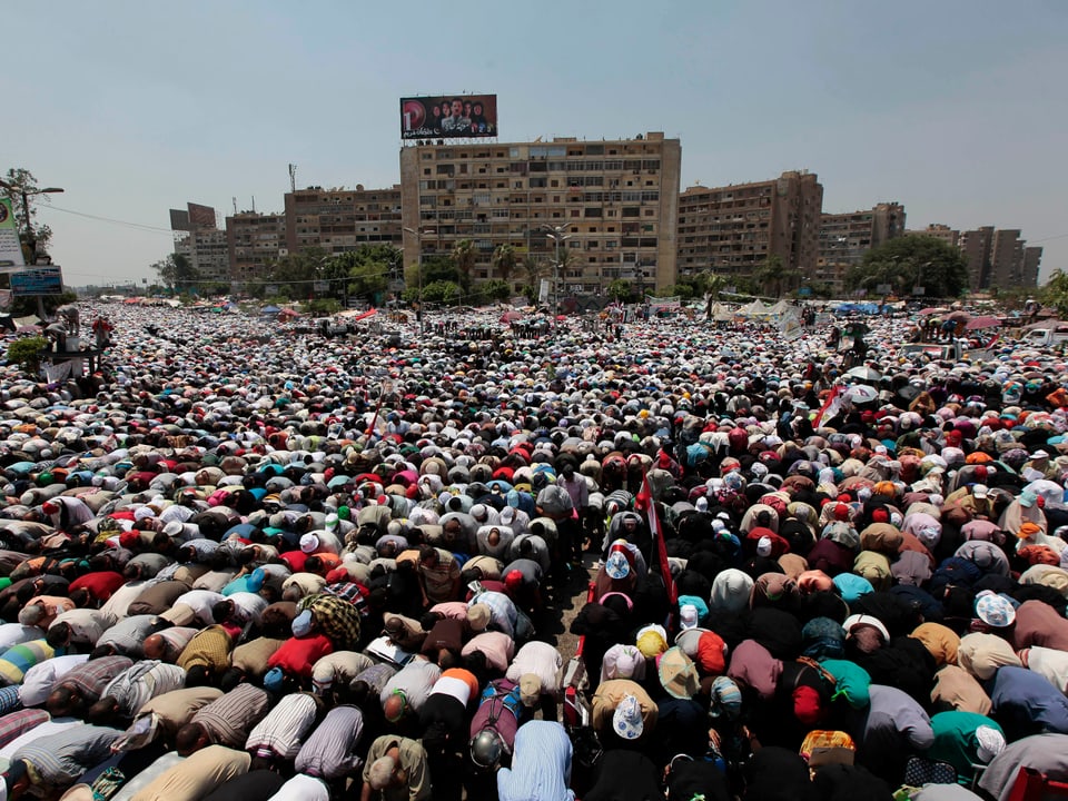 Zehntausende Betende vor einer Moschee. 