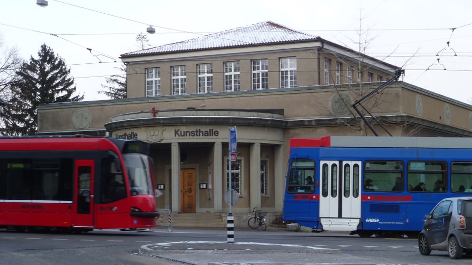 Rotes Tram und Blaues Bähnli kreuzen sich vor der Kunsthalle Bern. 