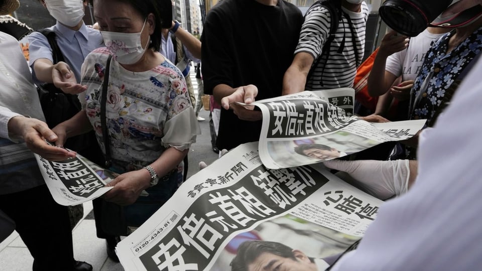 Menschen, die japanische Zeitungen kaufen