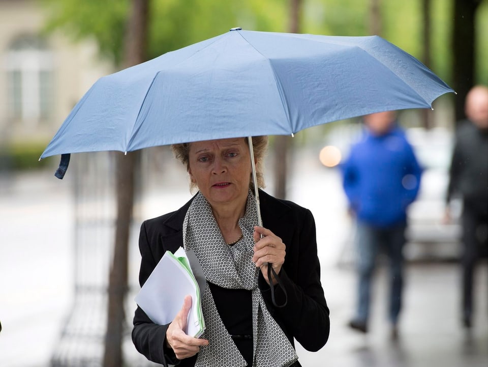 Bundesrätin Widmer-Schlumpf unter einem Regenschirm.