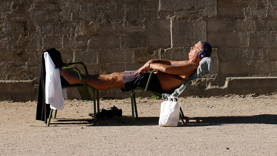 Mann in der Sonne auf Liegestuhl