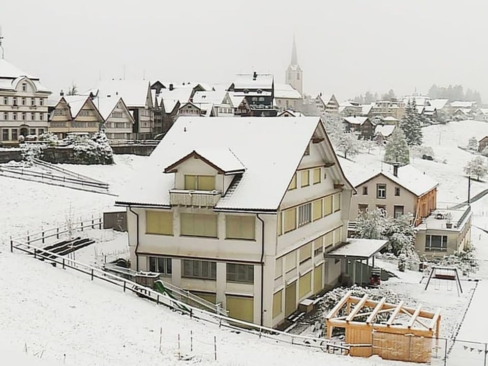 Verschneite Landschaft mit Häusern und Kirche