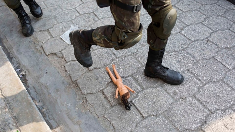 Ein Soldat steht knapp nicht auf eine nackte Barbiepuppe.