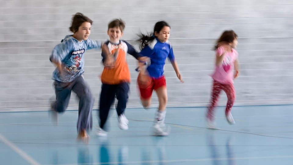 Kinder rennen durch Turnhalle.