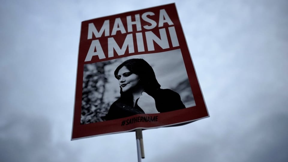 Plakat an einer Demo in Berlin, darauf zu sehen ein Foto von Mahsa Amini.