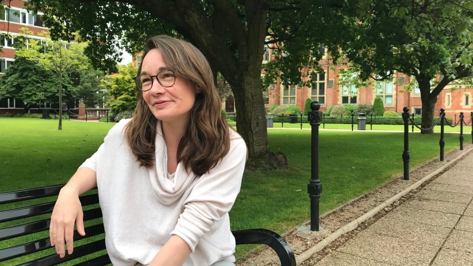 Katy Hayward, Professorin für politische Soziologie an der Queens University in Belfast sitzt auf einer Bank.