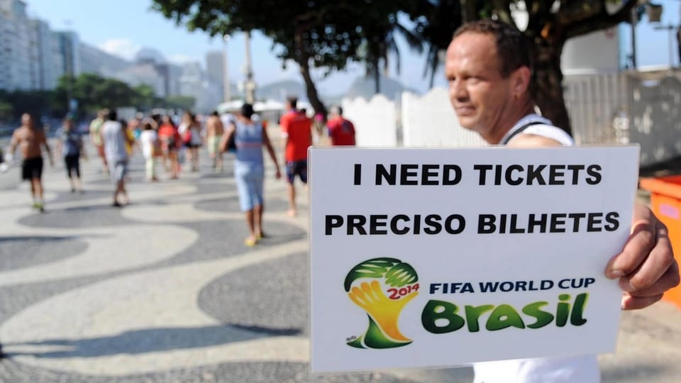 Mann an der Copacabana hält Schild mit der Aufschrift «suche Tickets» hoch