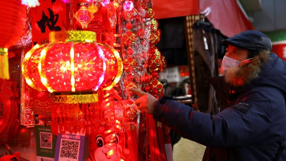 Ein Mann mit Maske ist an einem chinesischen Markt.