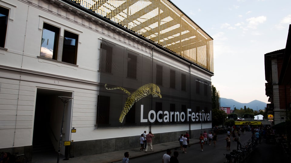Grosses Gebäude, an dessen Seite ein Fahne mit der Aufschrift "Locarno Festival" hängt.