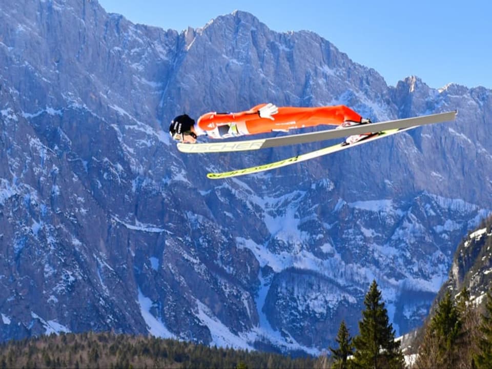 Ein Skispringer vor einer Bergkulisse