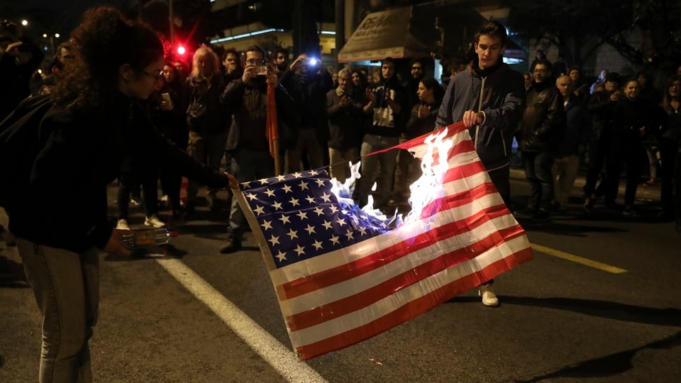 Demonstranten haben eine US-Flagge entzündet