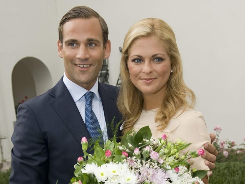 Junger Mann und junge Frau, elegant gekleidet, mit Blumenstrauss