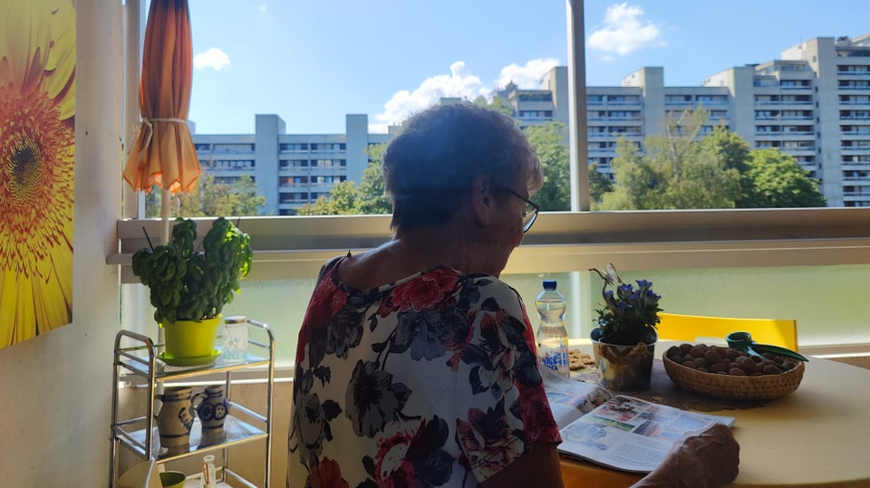 Frau liest Zeitschrift auf Balkon