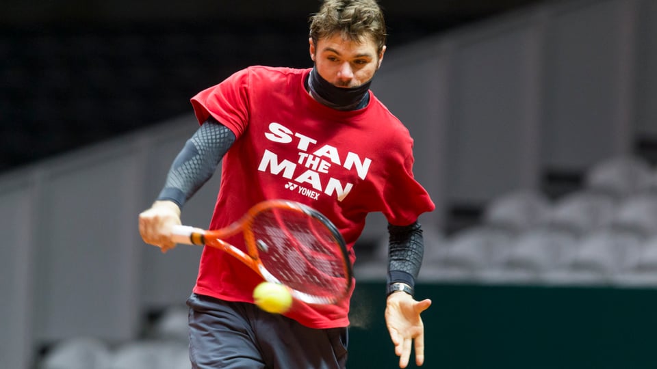 Stan Wawrinka in einem roten Shirt mit der Aufschrift "Stan the Man" schlägt im Training eine Rückhand.