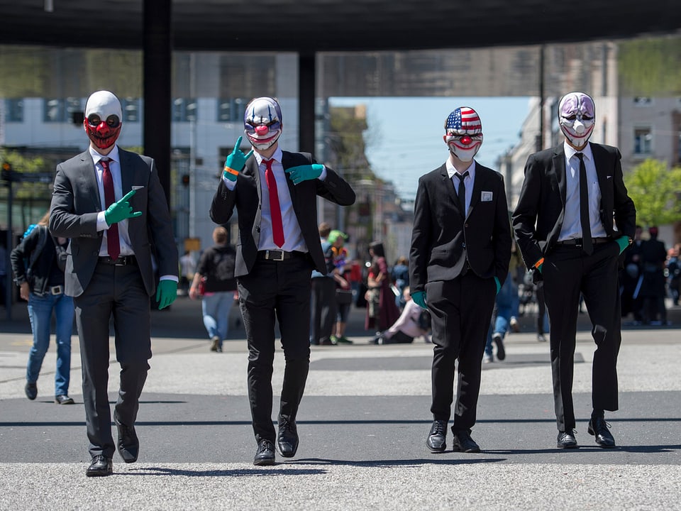 Vier kostümierte Männer gehen eine Strasse entlang