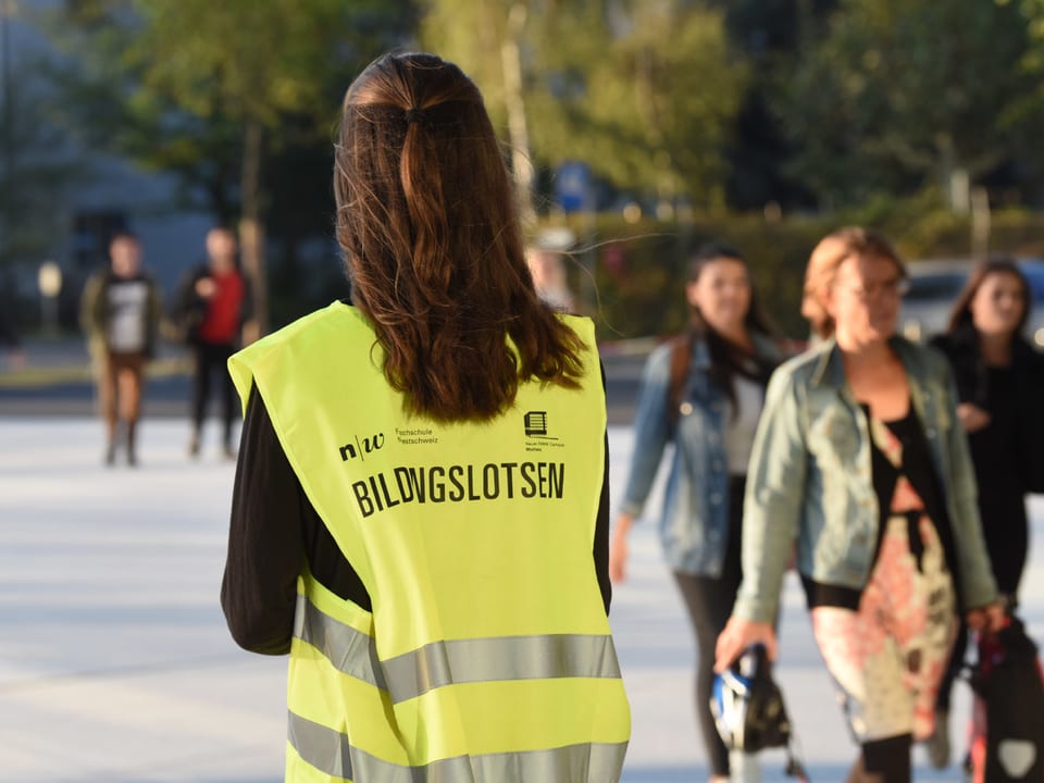 Eine Person trägt ein gelbes Trikot mit der Aufschrift Bildungslotsen
