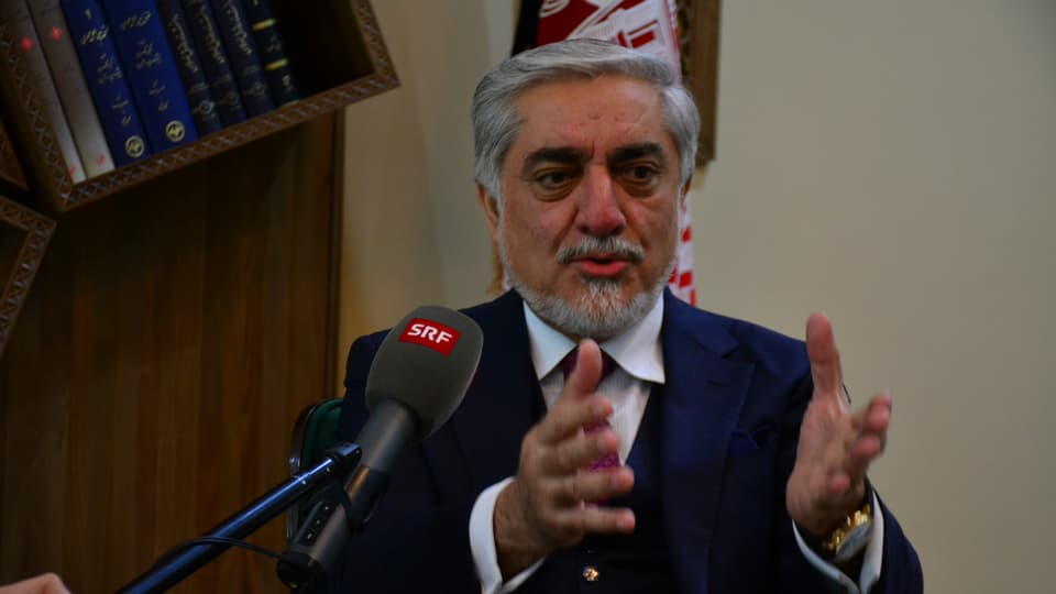 Abdullah spricht in ein SRF-Mikrofon und gestikuliert mit den Händen.