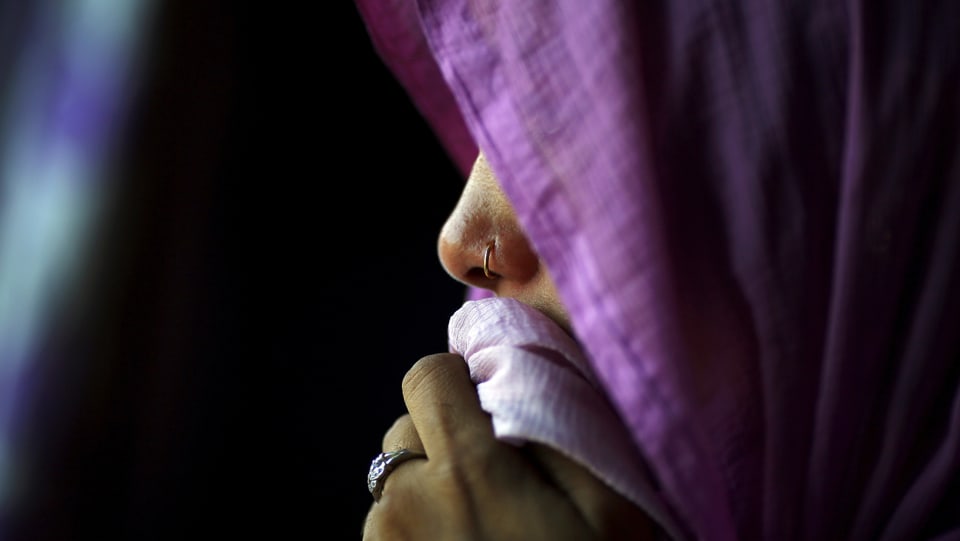 Indische Frau, das Gesicht verschwindet hinter einem Kopftuch. 
