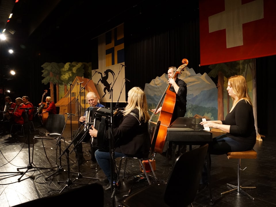 Eine vierköpfige Volksmusikformation mit Akkordeon, Klavier und Kontrabass auf einer Bühne.