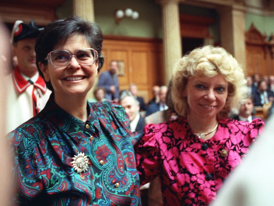 Ruth Dreifuss und Christiane Brunner stehen nebeneinander und lächeln nach der Wahl in den Bundesrat von Dreifuss.
