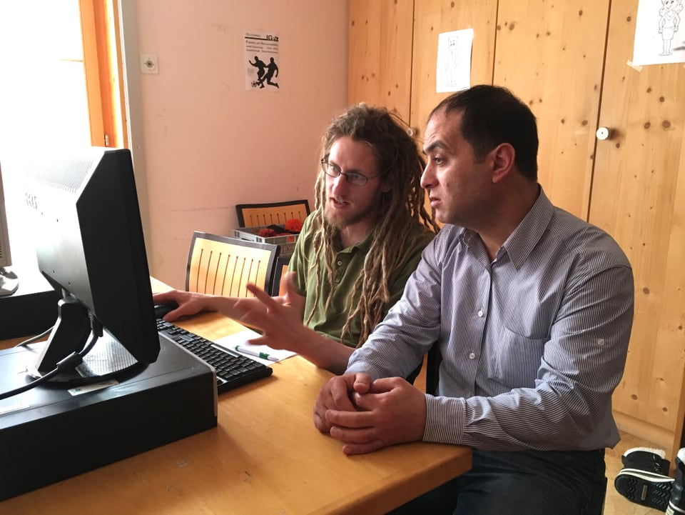 Zwei Männer sitzen vor einem Monitor