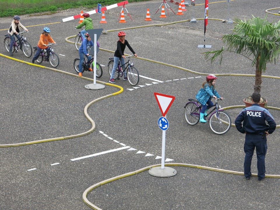 Mehrere Kinder fahren im Kreisverkehr.