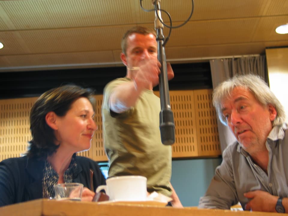 Charlotte Schwab und Ueli Jäggi Im Hörspielstudio, ein Tontechniker richtet das ikrofon ein