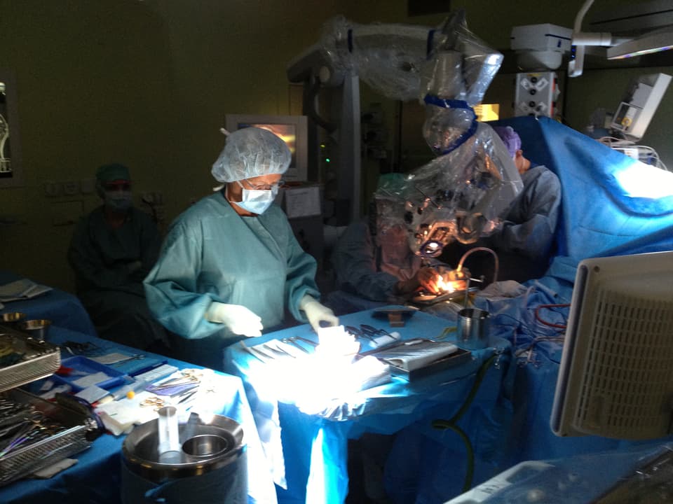 Operationsfachfrau Renate Nacht steht mit OP-Team während der Operation an der OP-Liege.