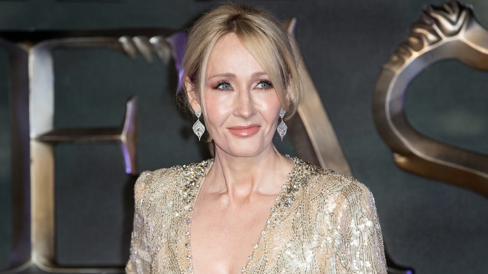 J.K. Rowling im goldenen Glitzerkleid posierend.