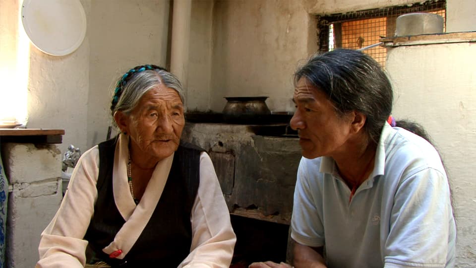 Tibi und seine leibliche Mutter Youden Jampa sitzen ihrer kargen Behausung.