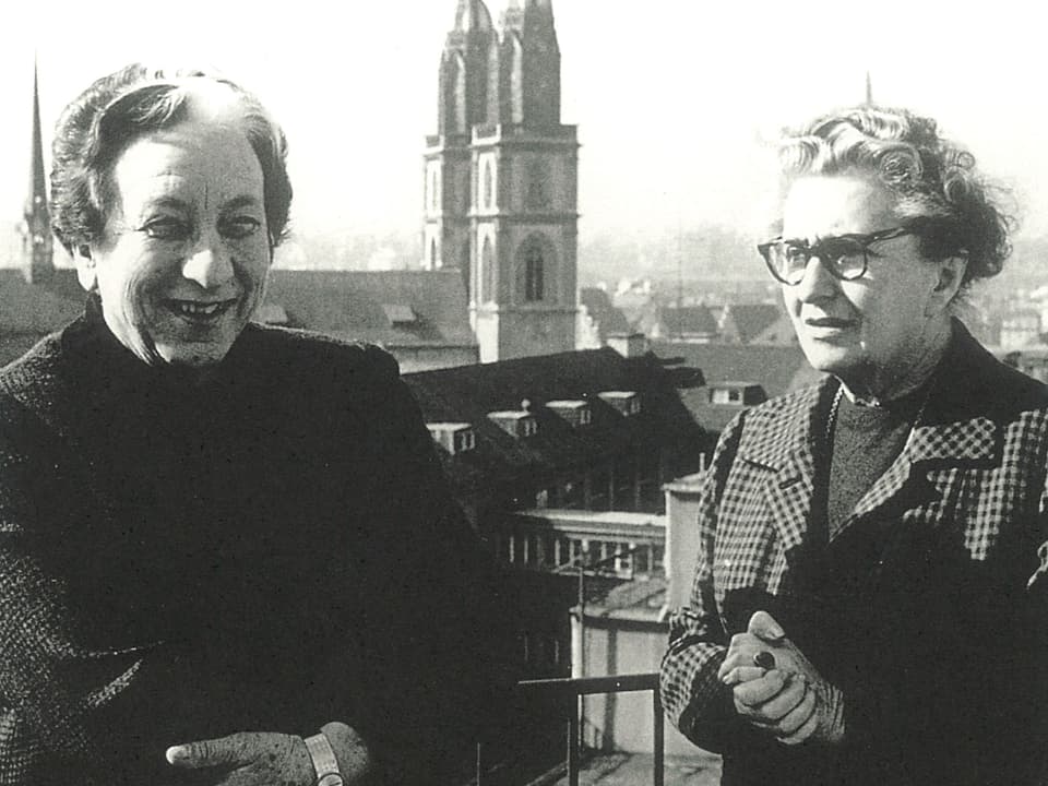Marguerite Steiger und Hermine Raths auf einem Schwarzweiss-Foto mit dem Zürcher Fraumünster im Hintergrund.