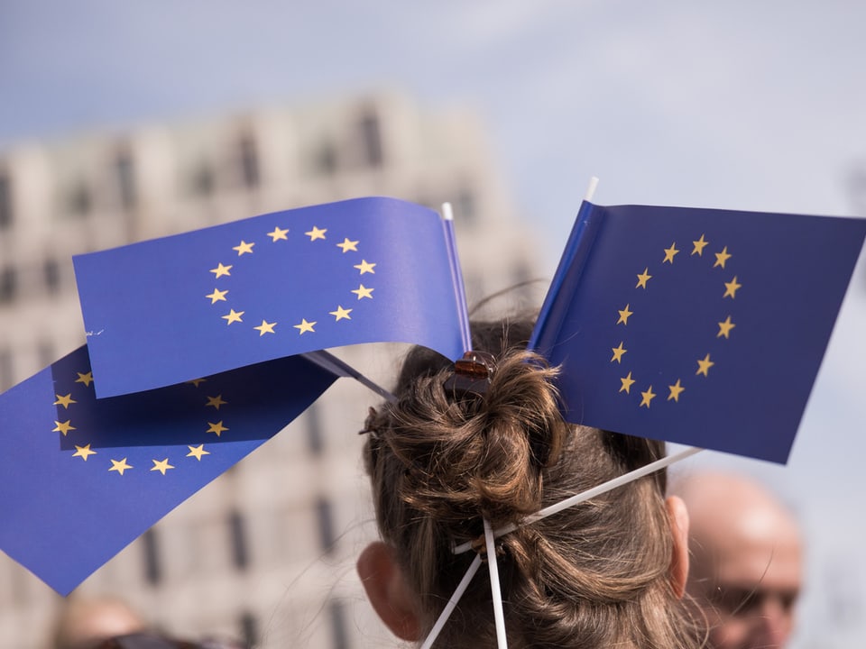 EIne Frau mit Europa-Flaggen in den Haaren