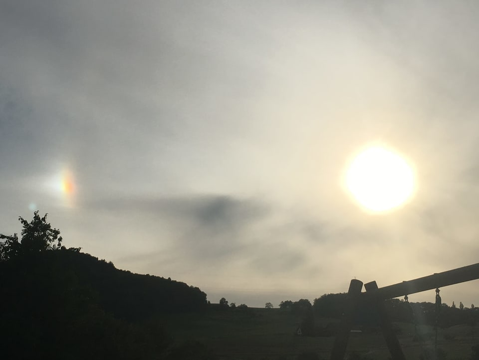 Abendhimmel mit Schleierwolken und rechts am Rand die Sonne. Links am Rand ist eine weitere helle Stelle erkennbar.