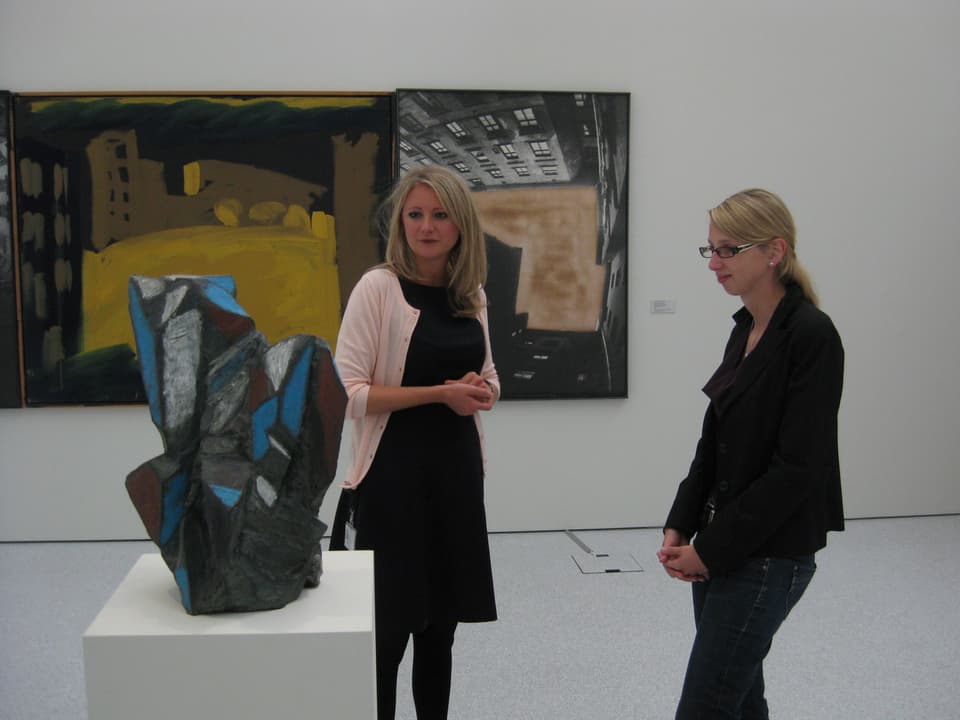 Zwei Frauen stehen vor einem Kunstwerk.