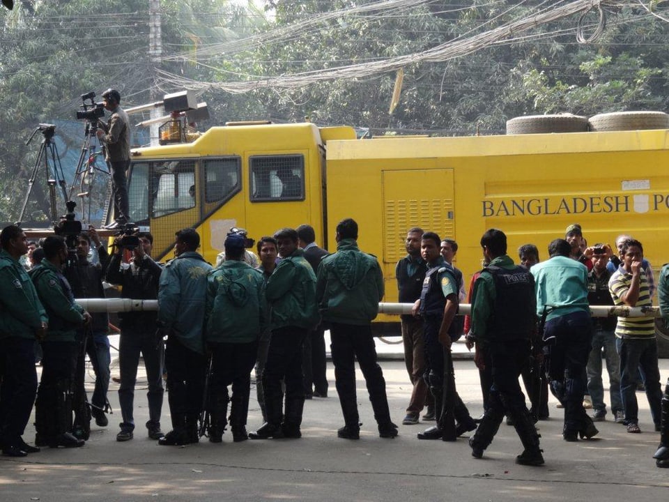Vor dem Haus von Oppositionsführerin Khaleda Zia patroullieren bewaffnete Polizisten. Wasserwerfer im Hintergrund. 
