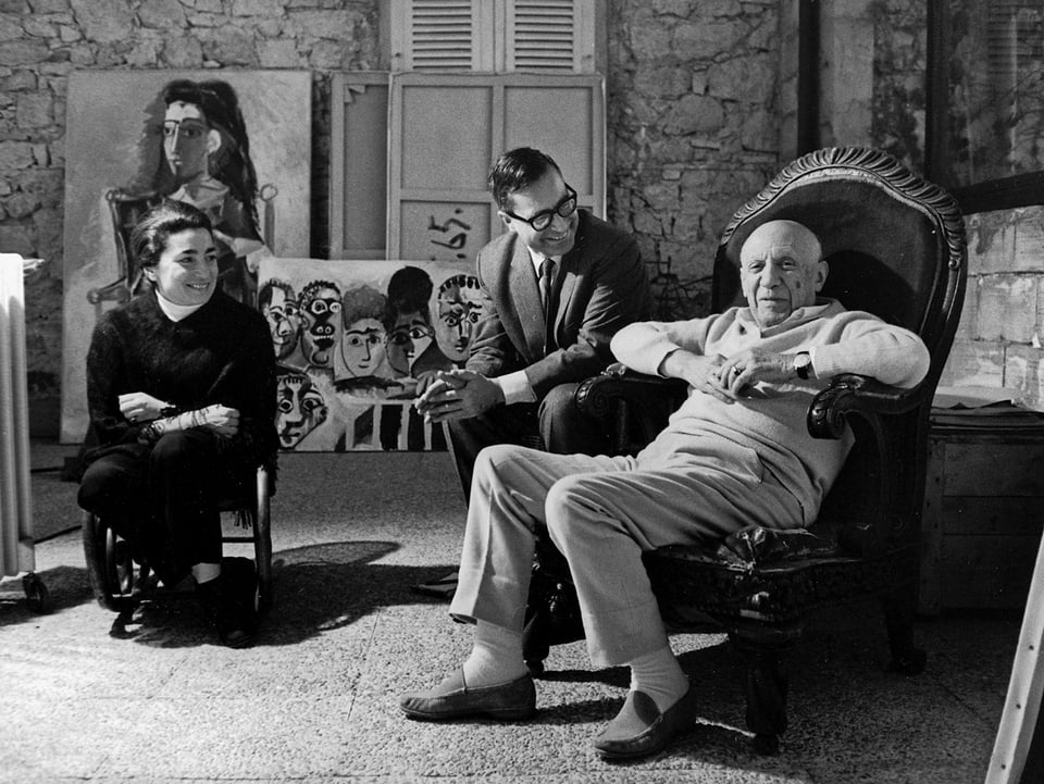 Pablo und Jacqueline Picasso und Museumsdirektor Franz Meyer sitzen in einer Runde.
