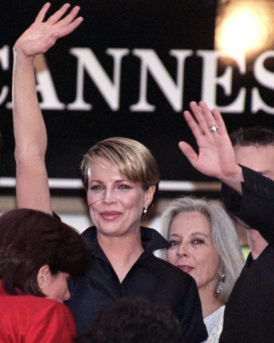 Schauspielerin Kim Basinger winkt in einer schwarzen Bluse am Filmfestival Cannes.