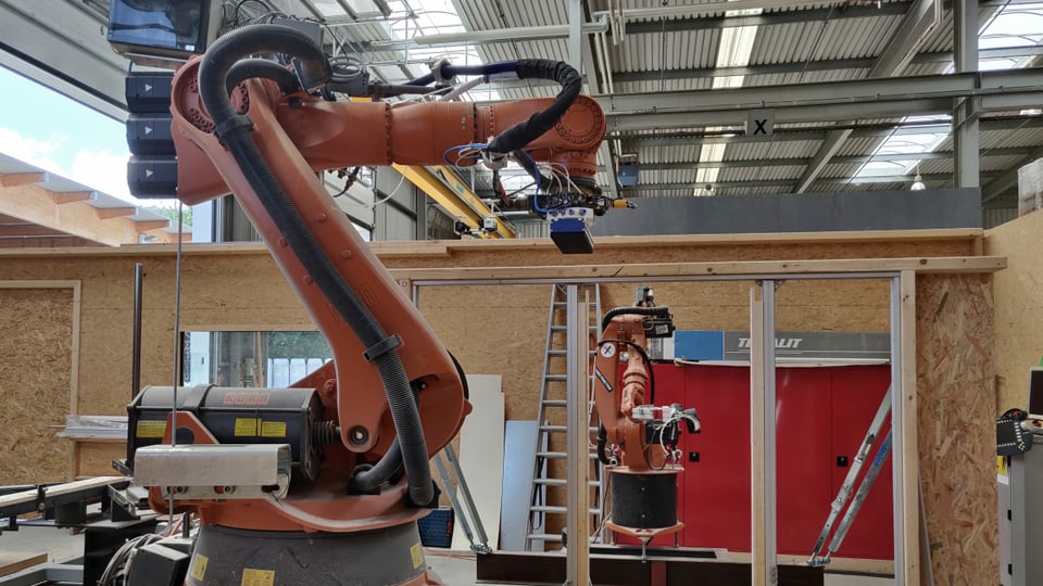 Zwei Roboterarme in einer Halle