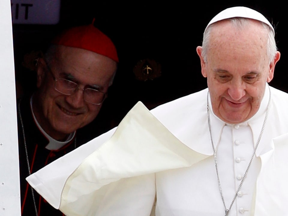 Papst Franziskus steigt aus einem Flugzeug. Bertone steht hinter ihm.