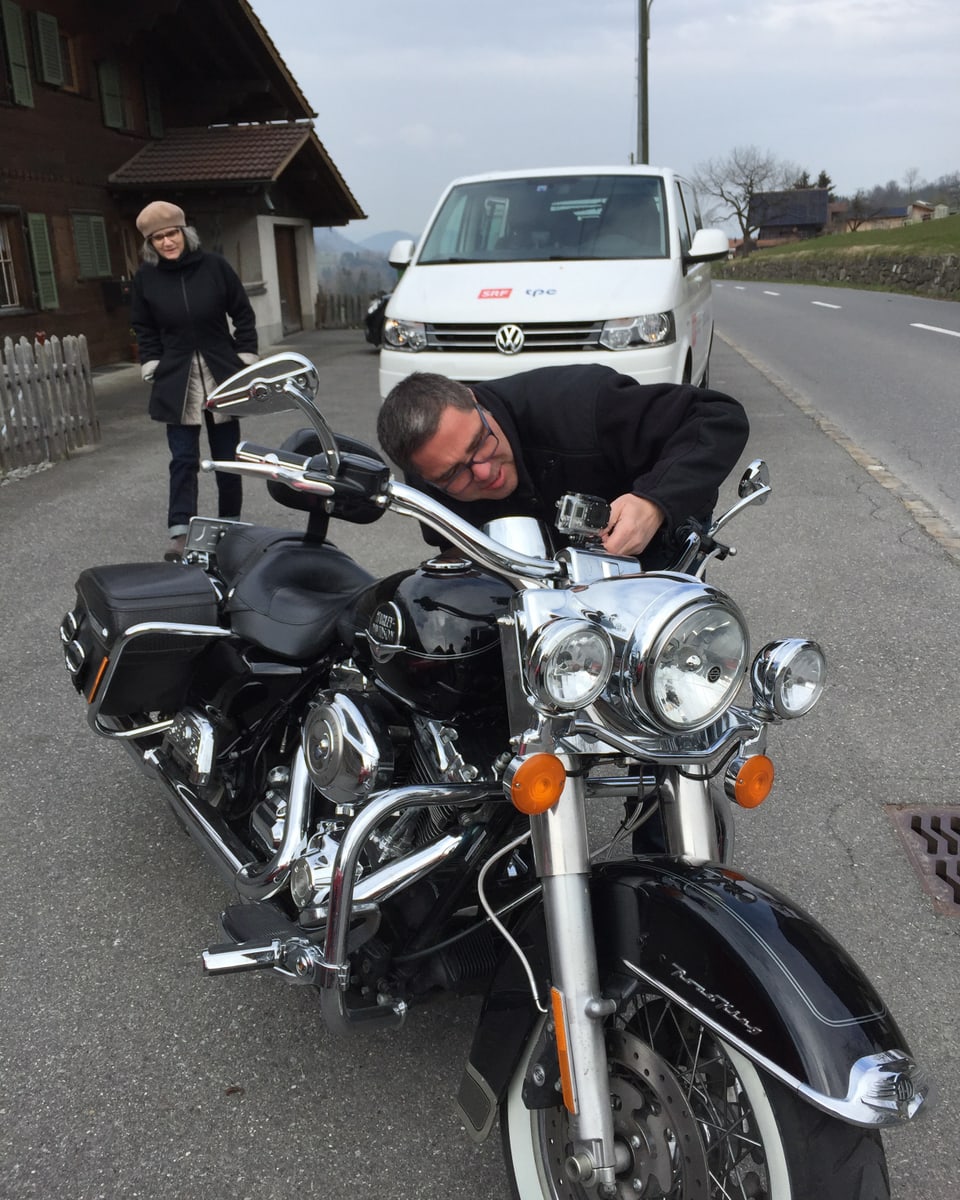 Peter Conrad montiert die Gopro auf Bernhards Motorrad.
