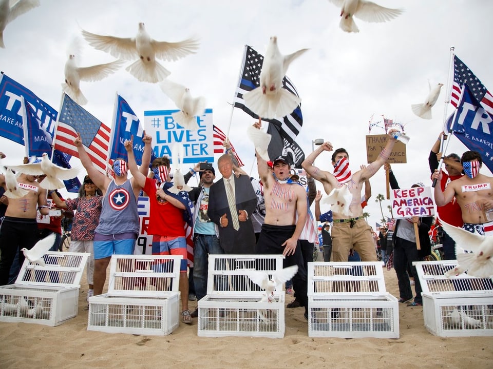 Trump-Befürworter lassen am Strand Tauben fliegen.