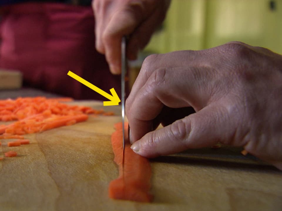 Mann schneidet Karotten in streifen.