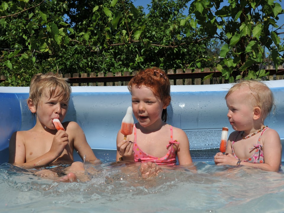 Kinder im Pool essen ein Glacé
